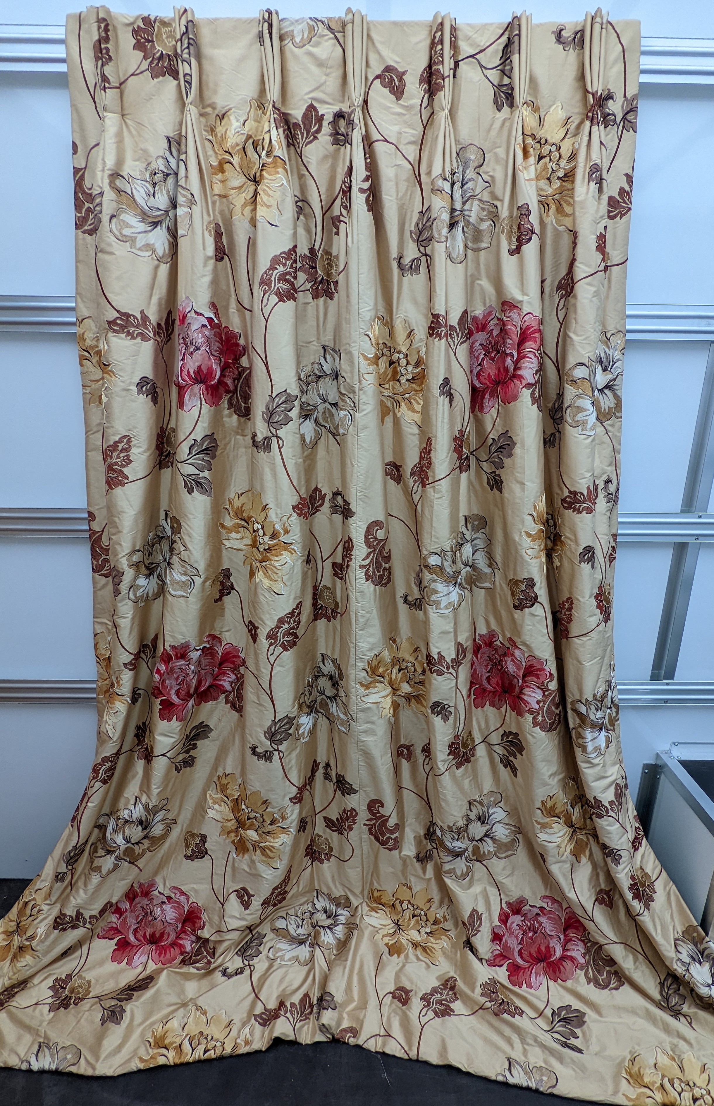 A pair of floral lined curtains. Approximate measurements: Width of top 110cm, Width of bottom 220cm Length 250cm